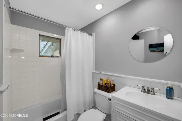 a bathroom with a sink mirror and toilet