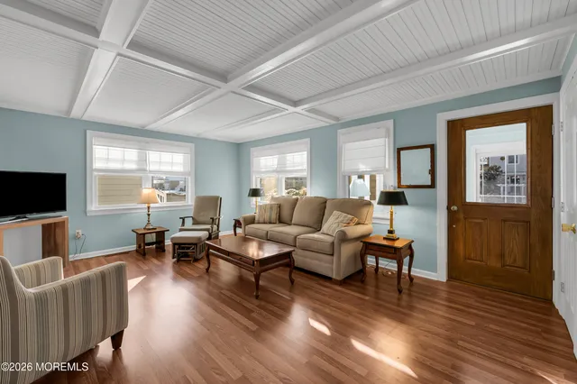 a living room with furniture flat screen tv and wooden floor