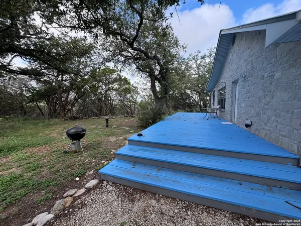 a view of a yard with wooden fence