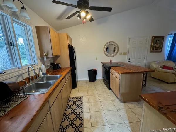 a large kitchen with a stove a sink dishwasher and a stove top oven with wooden floor