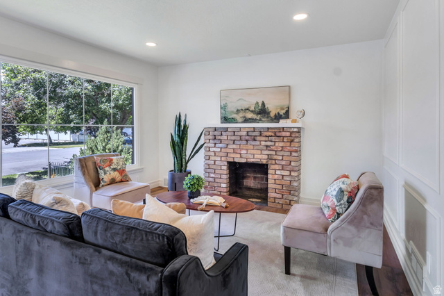 226 North 300 West Provo, UT 84601 - Photo 4 of 14 Living area featuring a brick-faced fireplace, large picture window, recessed lighting, and white paneled wall accents