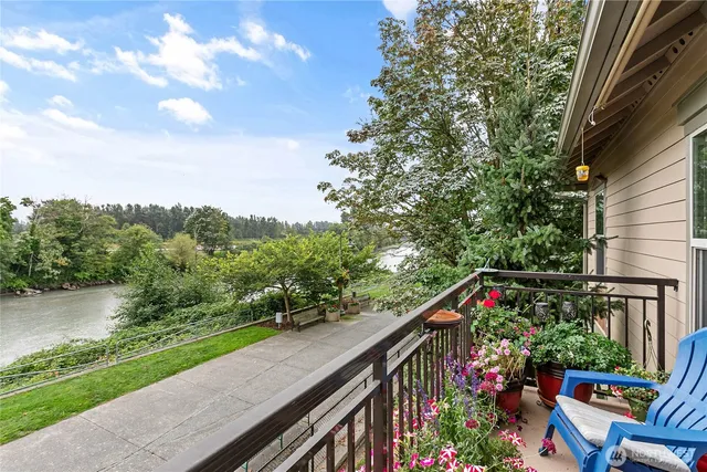 a balcony with wooden floor and outdoor seating