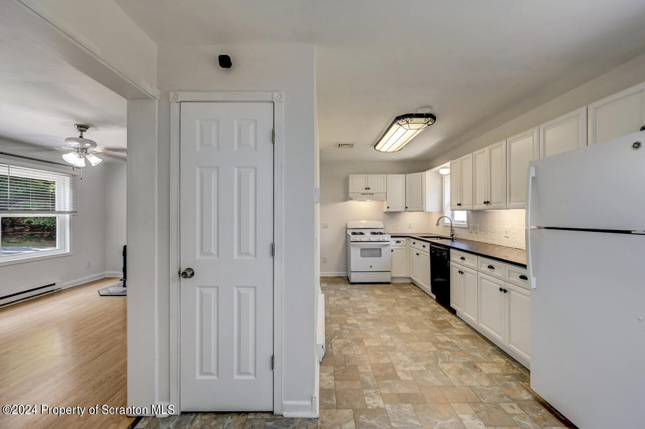 104 Bowens Road Moscow, PA 18444 - Photo 14 of 48 a kitchen with white cabinets and white appliances