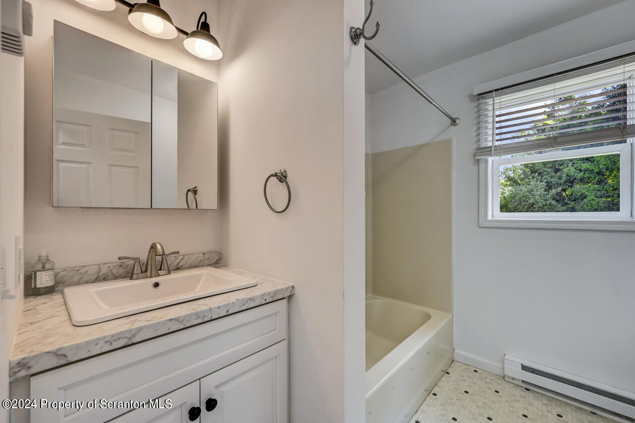 104 Bowens Road Moscow, PA 18444 - Photo 19 of 48 a bathroom with a sink a bathtub and a window