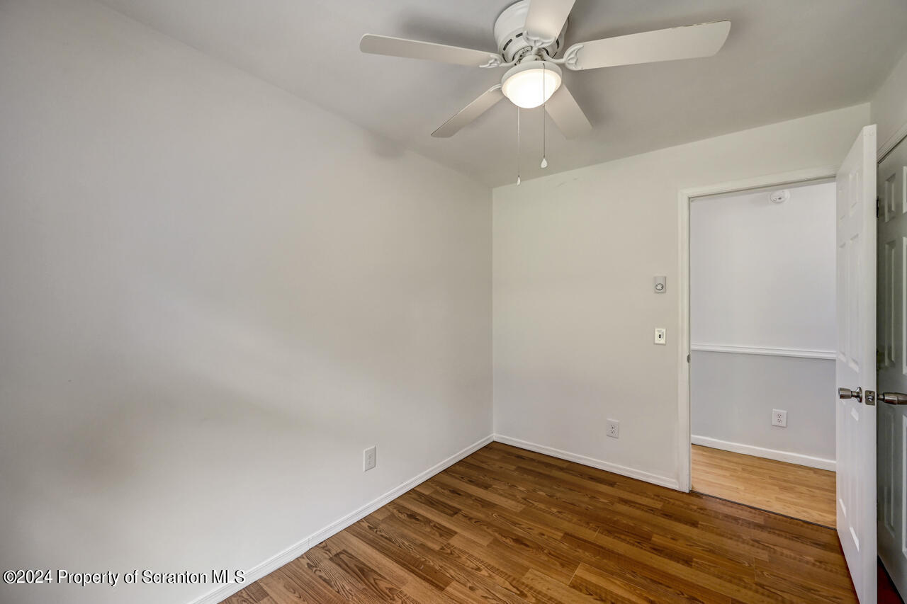 104 Bowens Road Moscow, PA 18444 - Photo 23 of 48 an empty room with wooden floor fan and windows