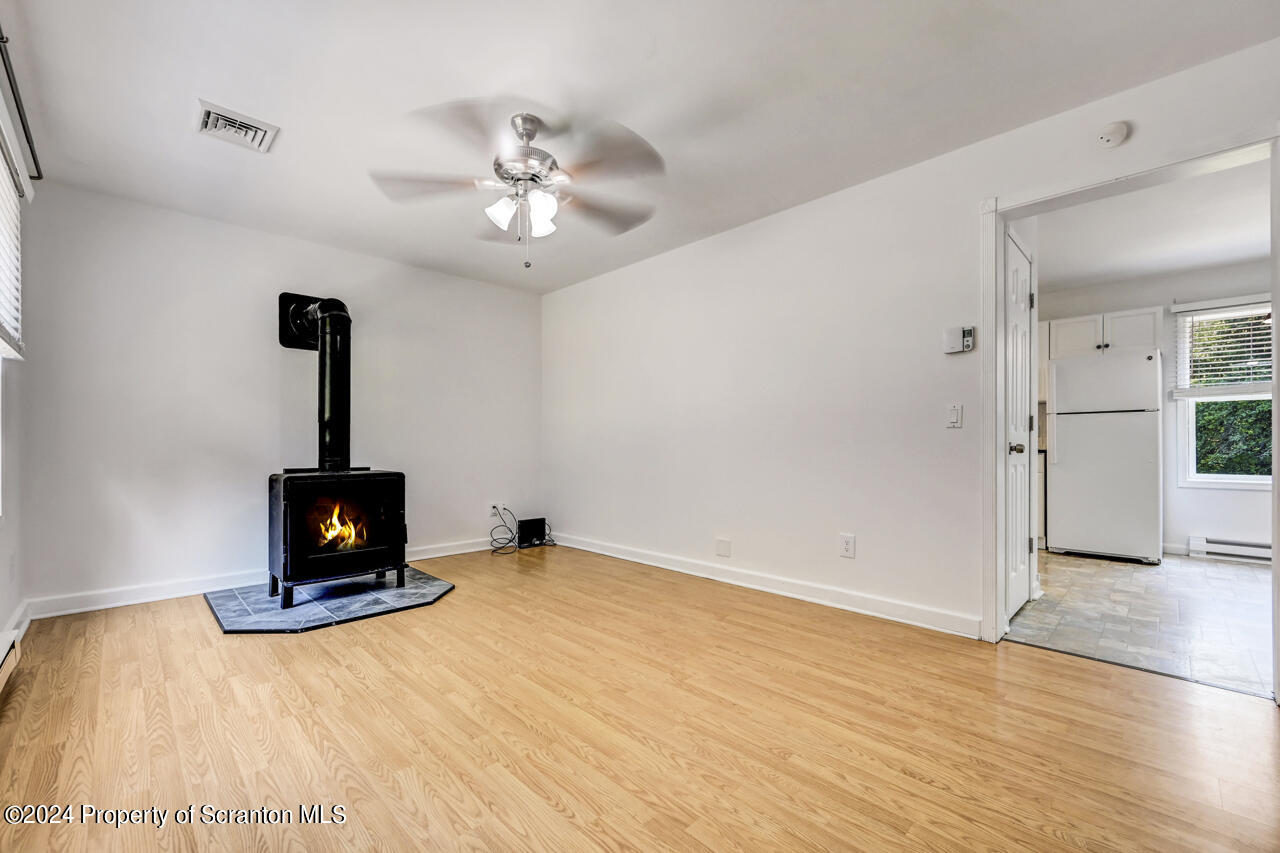104 Bowens Road Moscow, PA 18444 - Photo 5 of 48 a view of an empty room with wooden floor and a ceiling fan