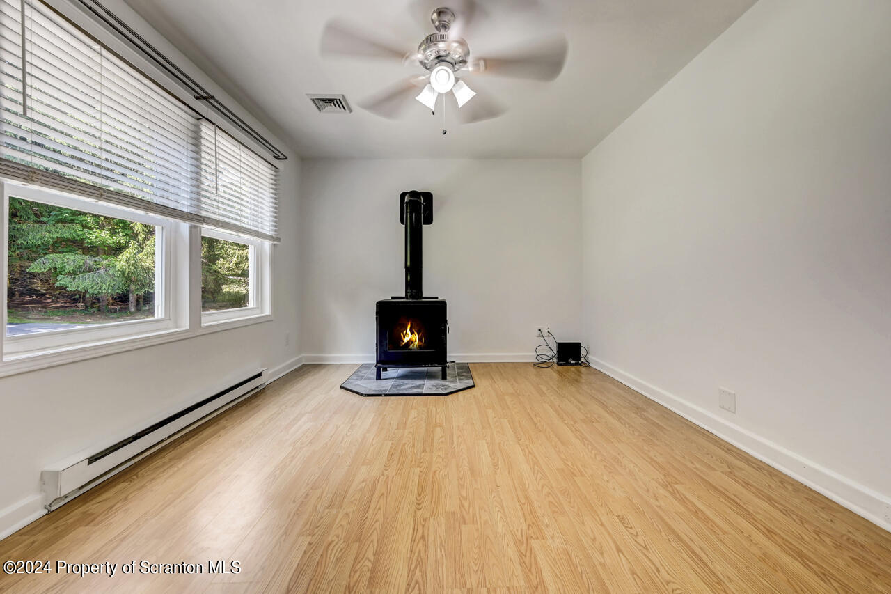 104 Bowens Road Moscow, PA 18444 - Photo 6 of 48 a view of a room with wooden floor a ceiling fan and windows