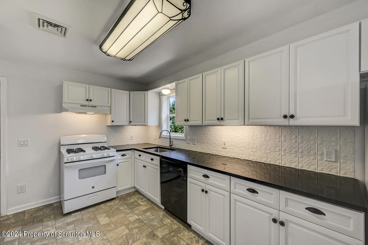 104 Bowens Road Moscow, PA 18444 - Photo 8 of 48 a kitchen with granite countertop white cabinets and white appliances
