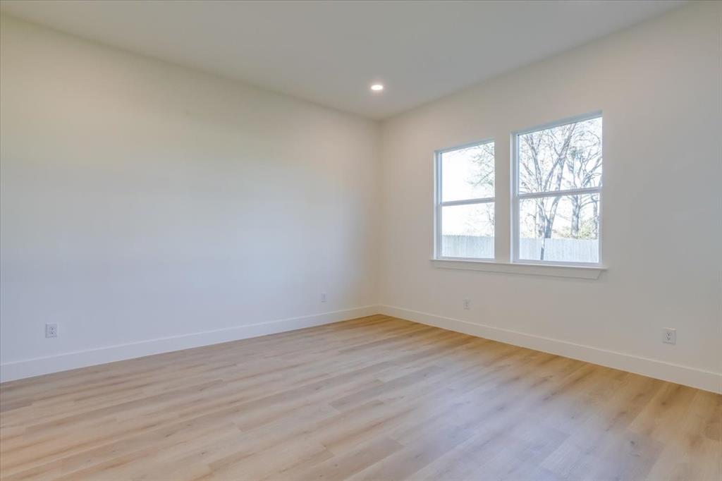 1507 Elk Creek Road Dallas, TX 75253 - Photo 16 of 40 a view of an empty room with wooden floor and a window