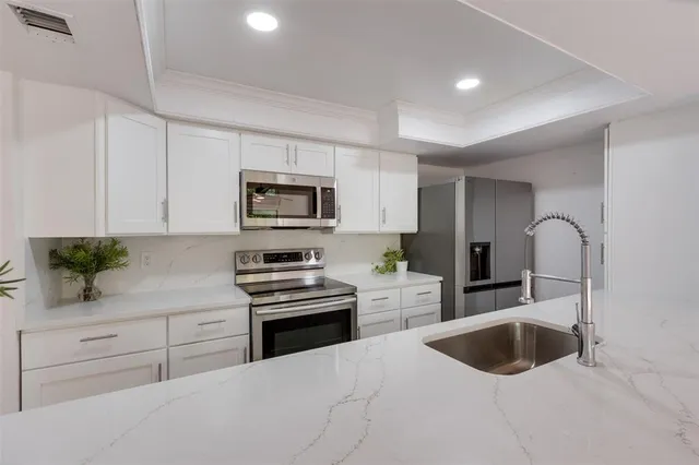 a kitchen with a sink cabinets and stainless steel appliances