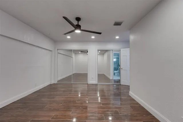 a view of an empty room with wooden floor