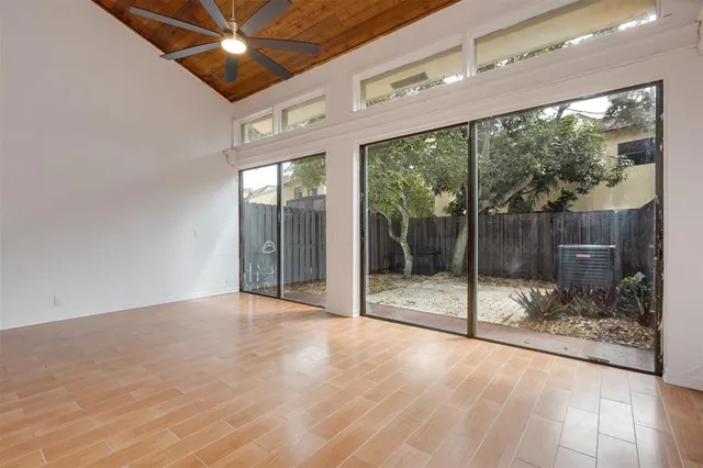 a view of a room with wooden floor and a floor to ceiling window