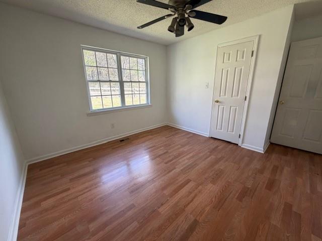 425 Chubbtown Road Cedartown, GA 30125 - Photo 19 of 29 an empty room with wooden floor fan and windows
