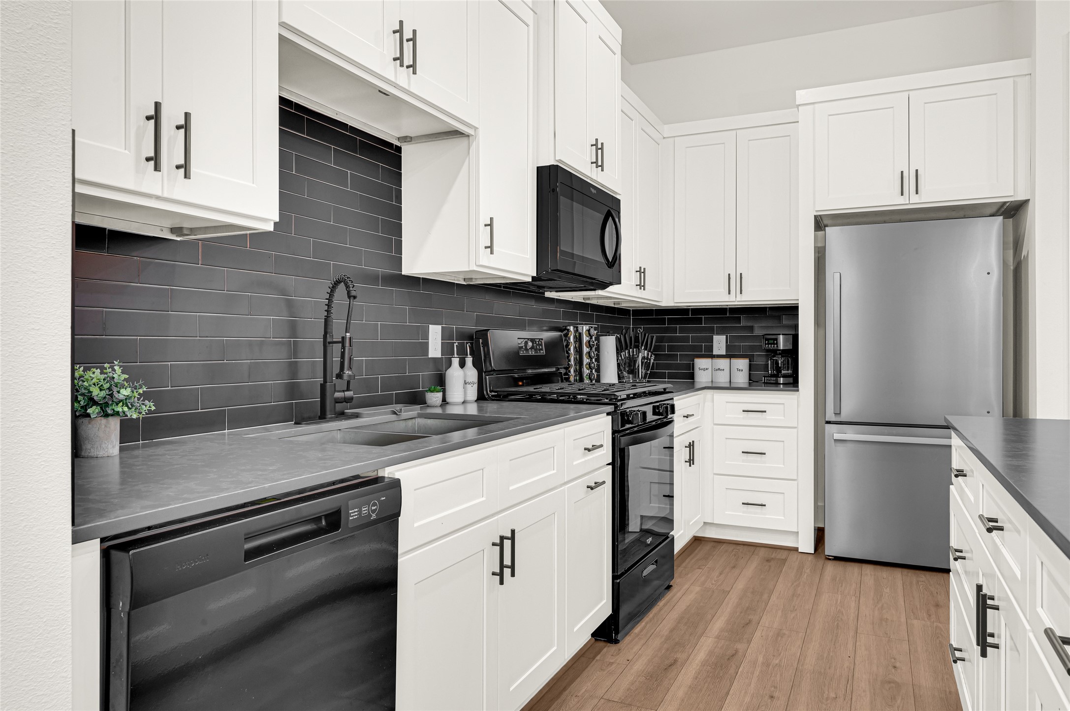 4201 Stassen Street Houston, TX 77051 - Photo 8 of 39 a kitchen with stainless steel appliances a refrigerator sink and white cabinets