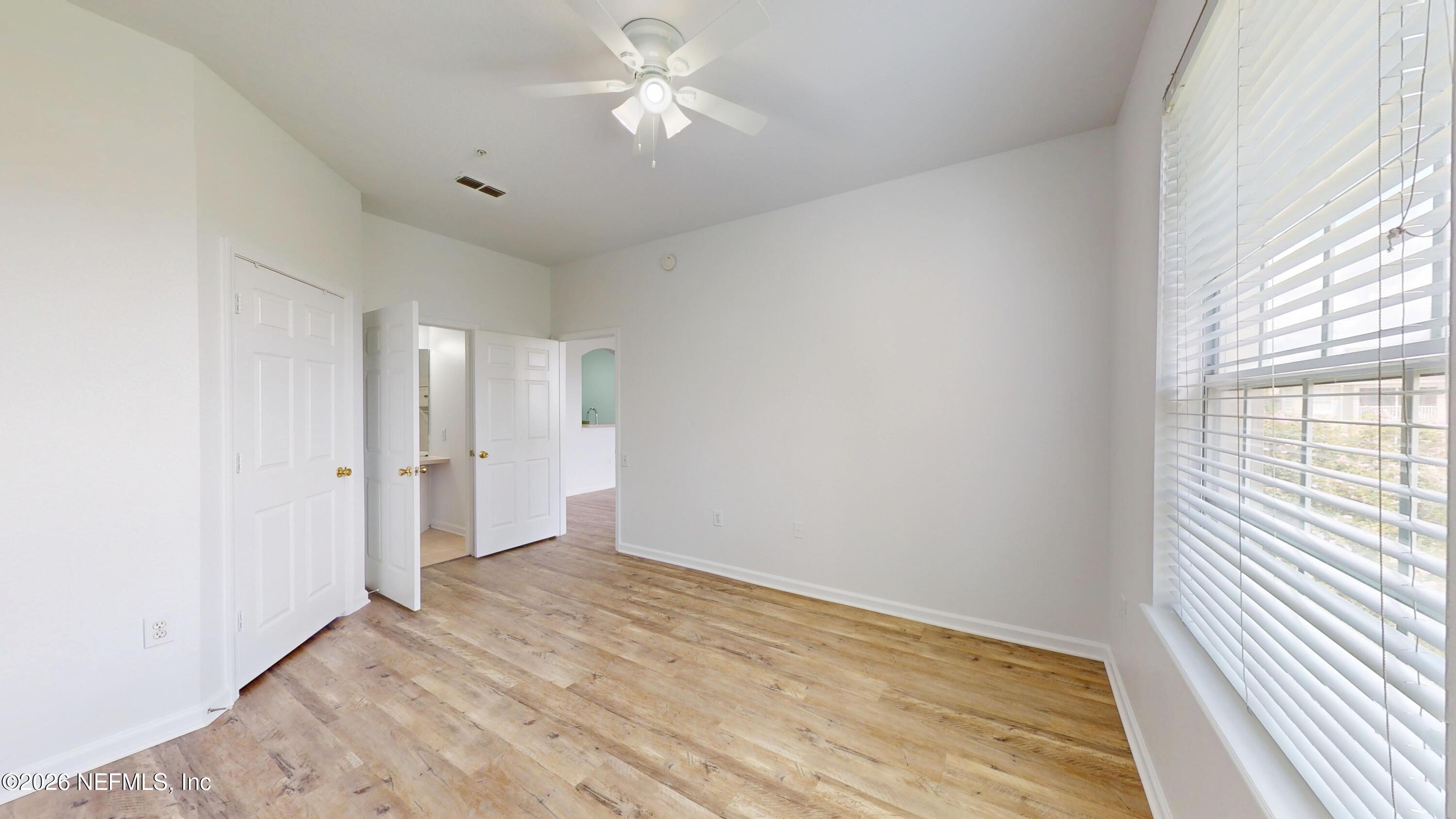 7990 Baymeadows Road East, Unit 912 Jacksonville, FL 32256 - Photo 12 of 25 wooden floor in an empty room with a window