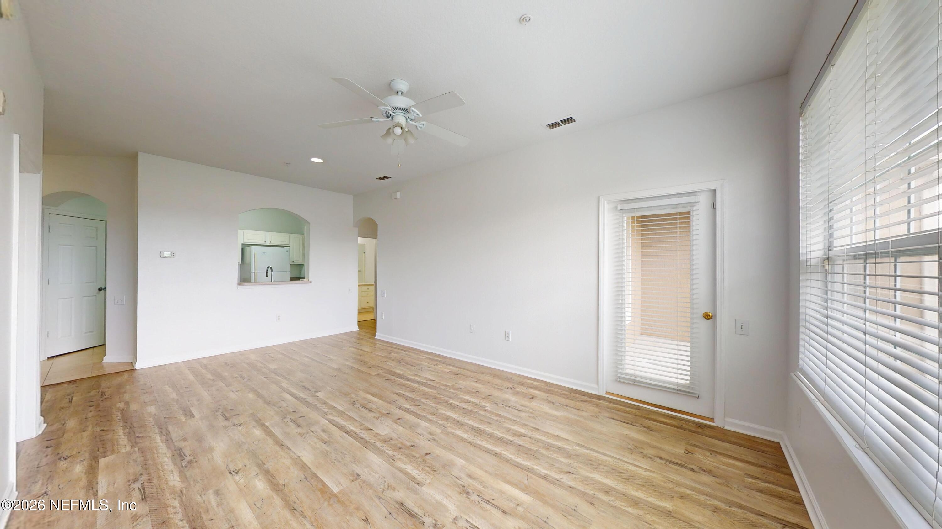 7990 Baymeadows Road East, Unit 912 Jacksonville, FL 32256 - Photo 4 of 25 wooden floor in an empty room with a window