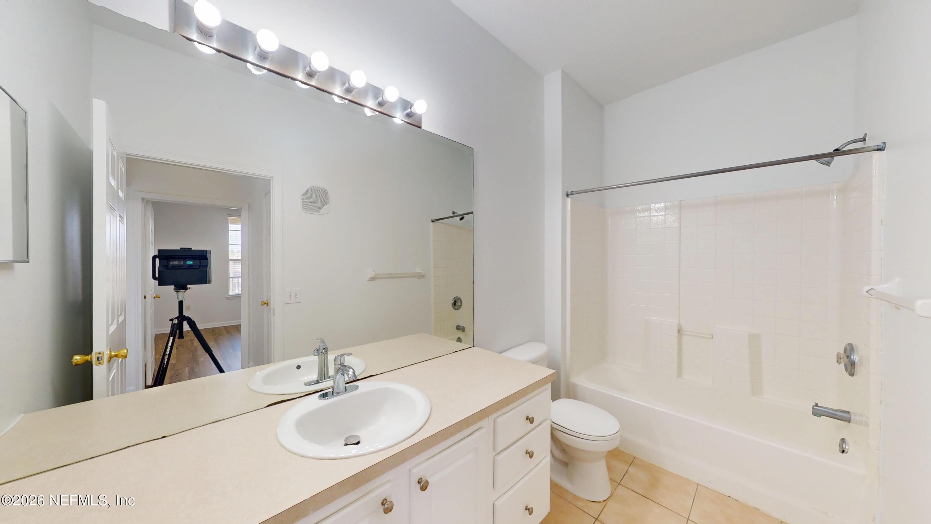 7990 Baymeadows Road East, Unit 912 Jacksonville, FL 32256 - Photo 8 of 25 a bathroom with a sink a toilet and shower a mirror