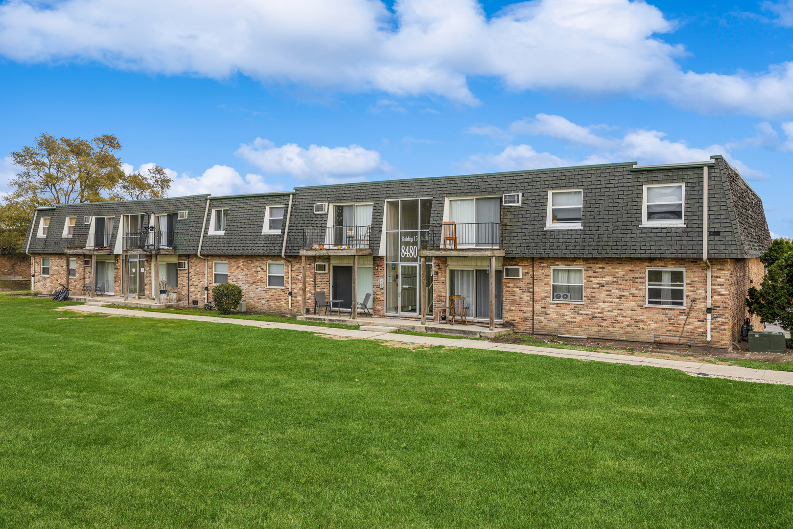 a front view of a house with a garden and yard
