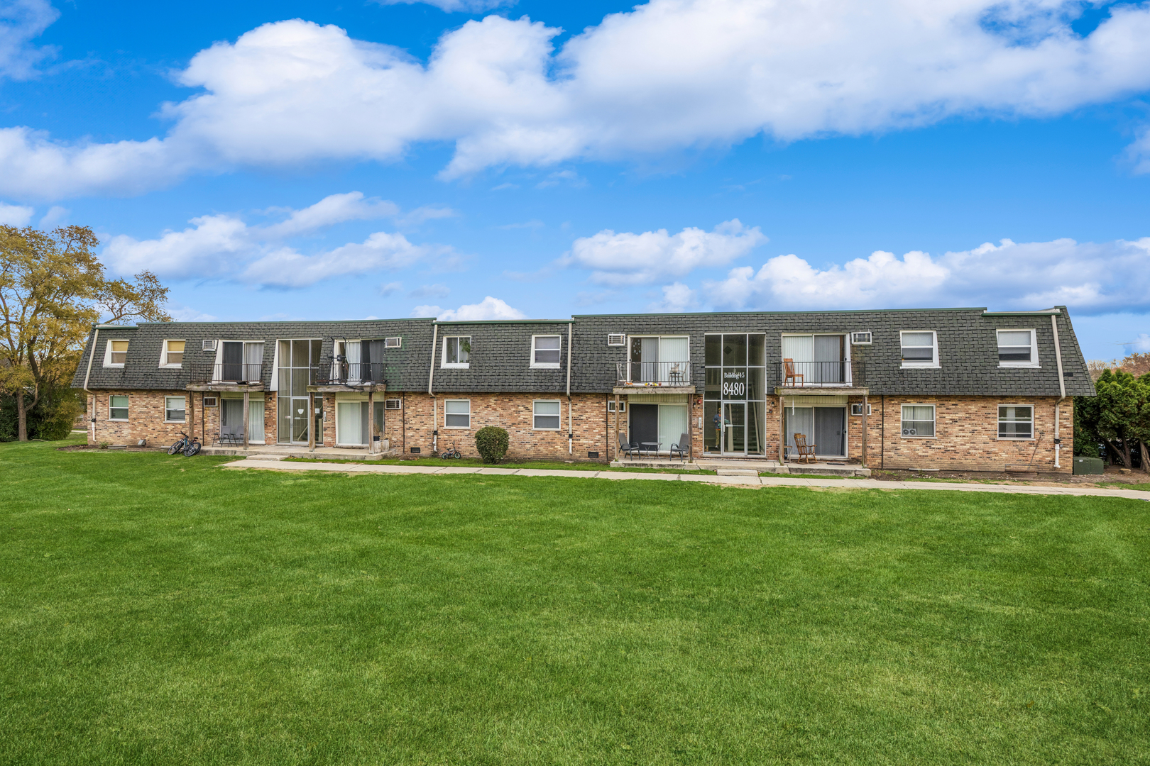 8480 West 103rd Terrace, Unit 301 Palos Hills, IL 60465 - Photo 2 of 17 a view of a house next to a big yard and large trees