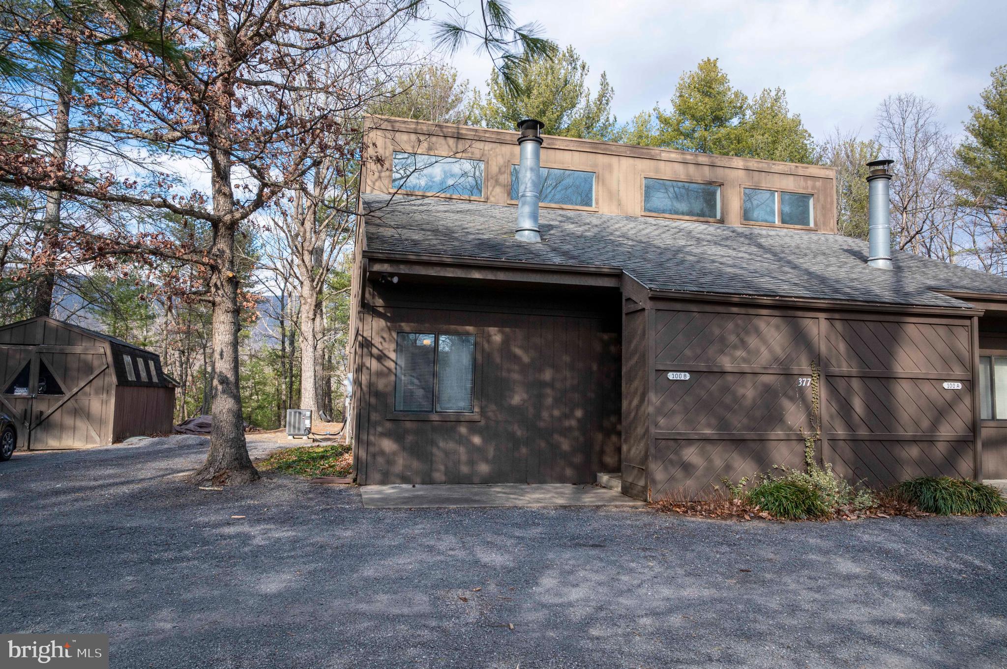 377 Spitz Lane, Unit 100 Basye, VA 22810 - Photo 37 of 69 a view of a house with a patio and a yard