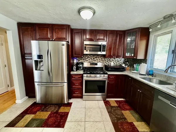 a kitchen with stainless steel appliances granite countertop a refrigerator stove and sink