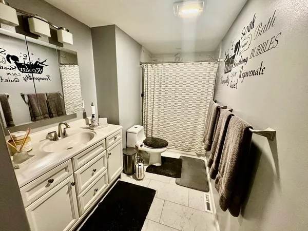 a bathroom with a sink and mirror with bathtub