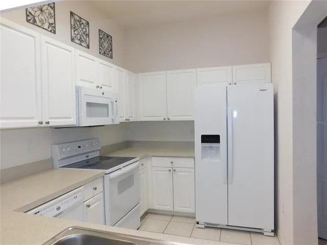 a kitchen with white cabinets and white appliances
