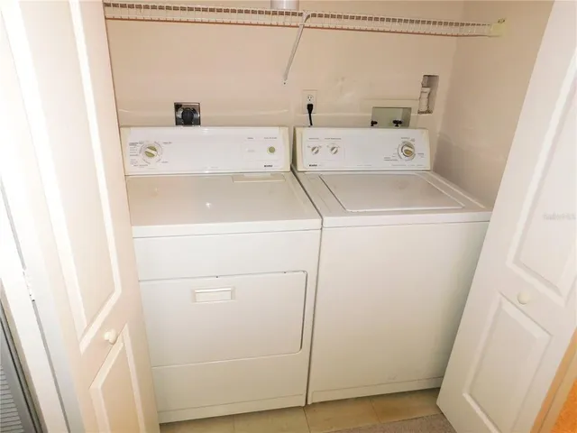 an empty room with a chandelier fan and windows