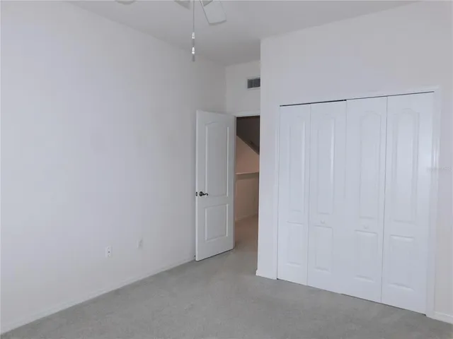 a view of a hallway with white walls and stairs
