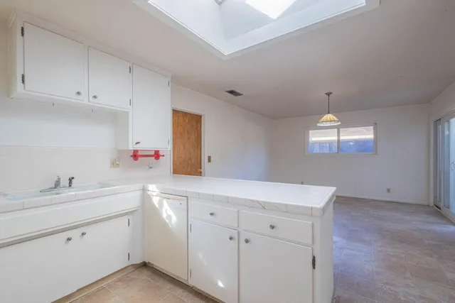 a kitchen with white cabinets and sink