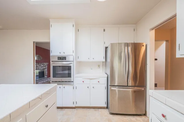 a kitchen with stainless steel appliances a refrigerator sink and cabinets
