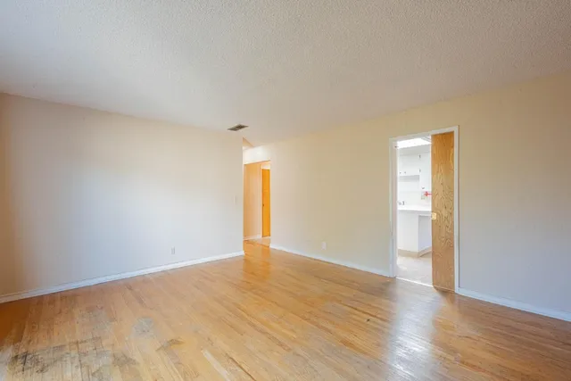 a view of an empty room and wooden floor