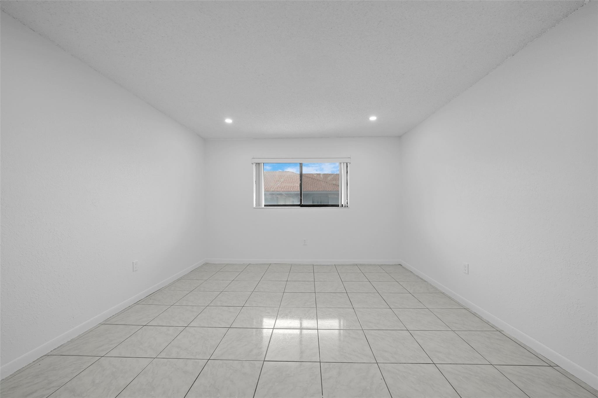 230 West 68th Street, Unit 208 Hialeah, FL 33014 - Photo 21 of 23 an empty room with white walls and tiles