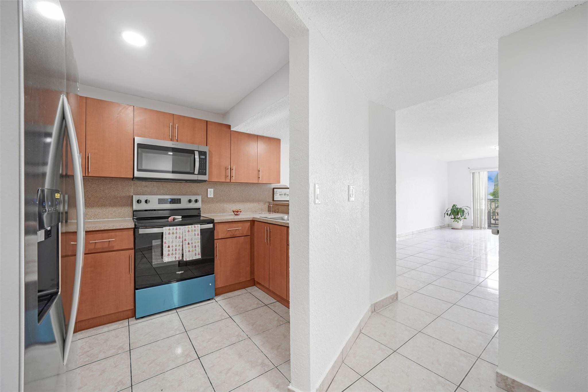 230 West 68th Street, Unit 208 Hialeah, FL 33014 - Photo 5 of 23 a kitchen with granite countertop a refrigerator and a stove top oven