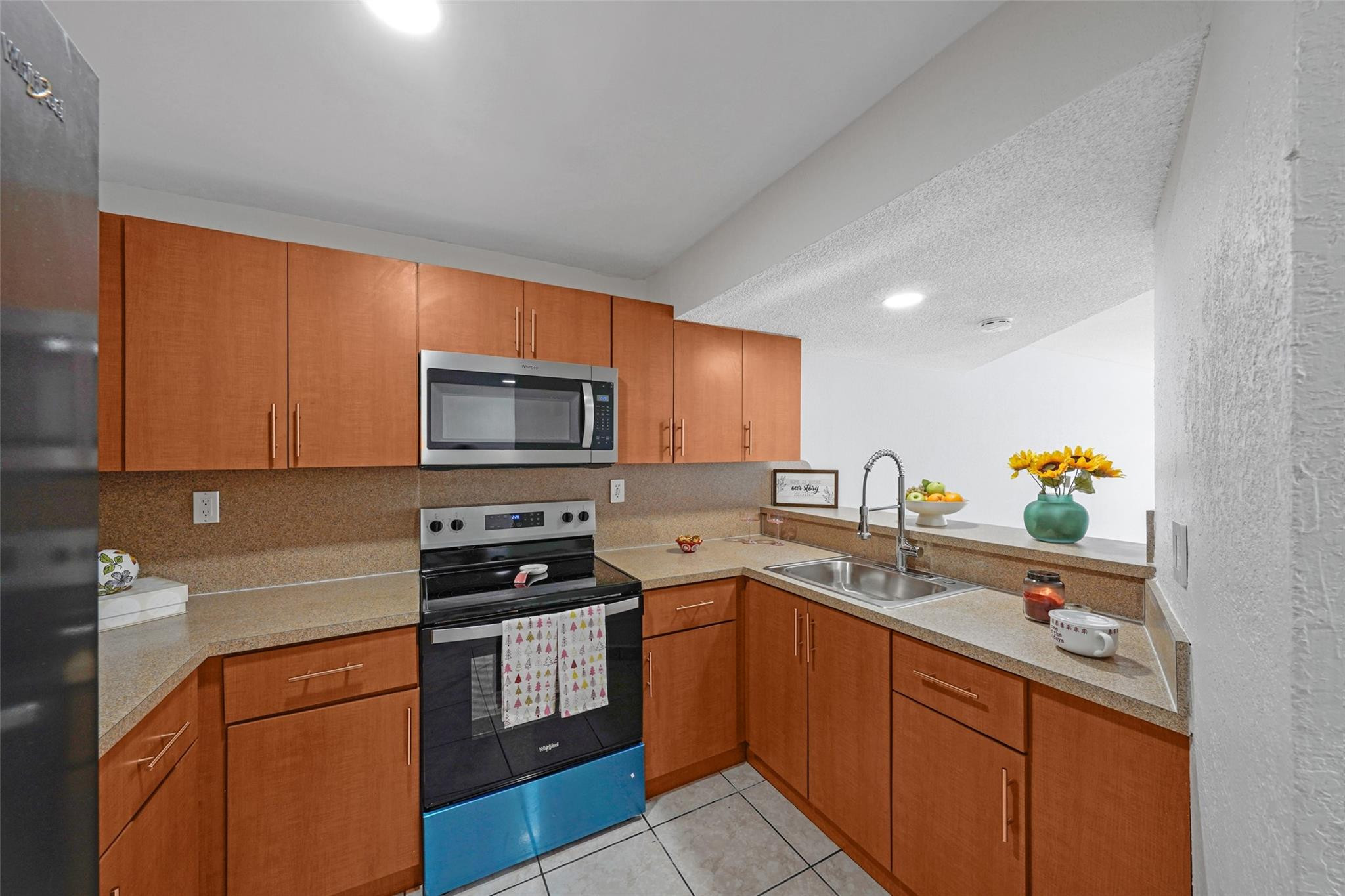 230 West 68th Street, Unit 208 Hialeah, FL 33014 - Photo 7 of 23 a kitchen with stainless steel appliances a stove sink microwave and cabinets