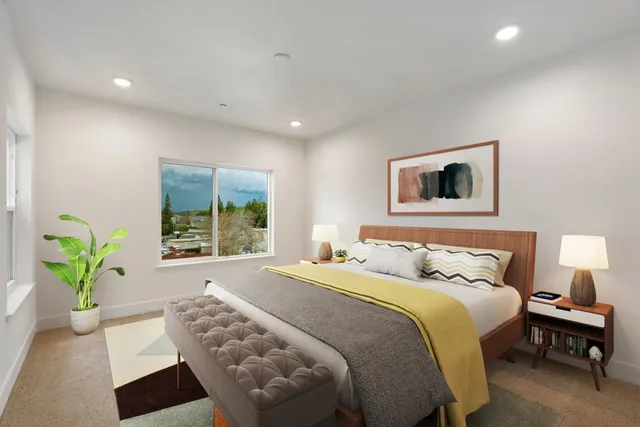 a bedroom with a bed a painting and a window