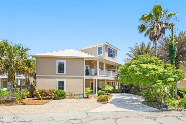 a front view of a house with a yard and tree s