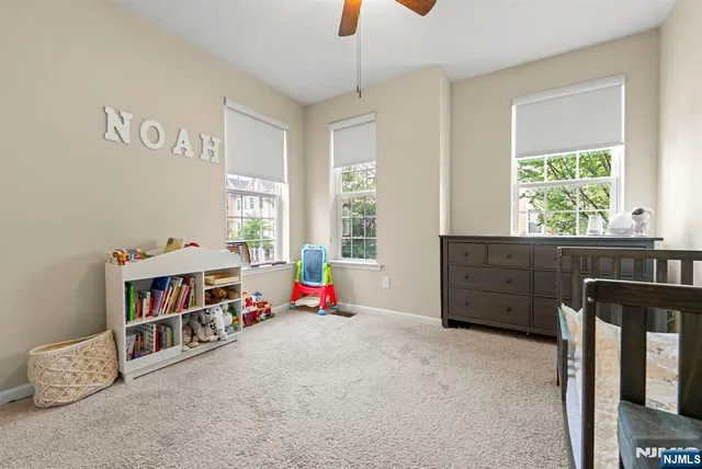 a living room with baby crib furniture and a window