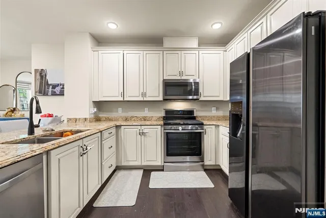 a kitchen with stainless steel appliances granite countertop a refrigerator and a sink