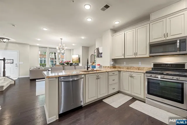 a large kitchen with stainless steel appliances granite countertop a stove a sink and a microwave