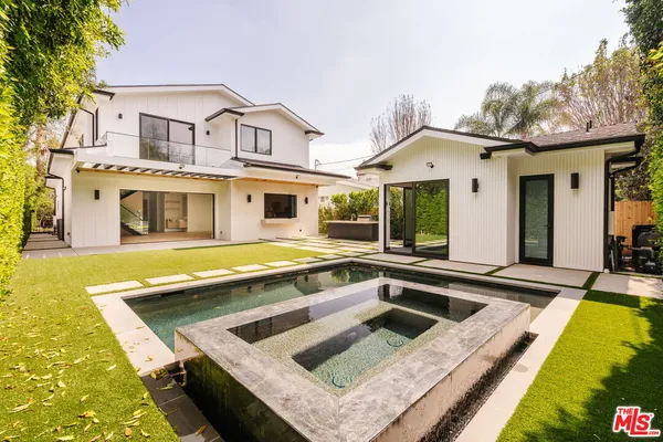 a view of a house with swimming pool and sitting area