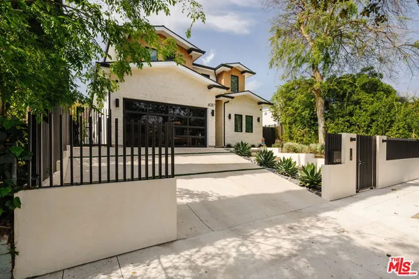 a view of a house with a small yard and potted plants