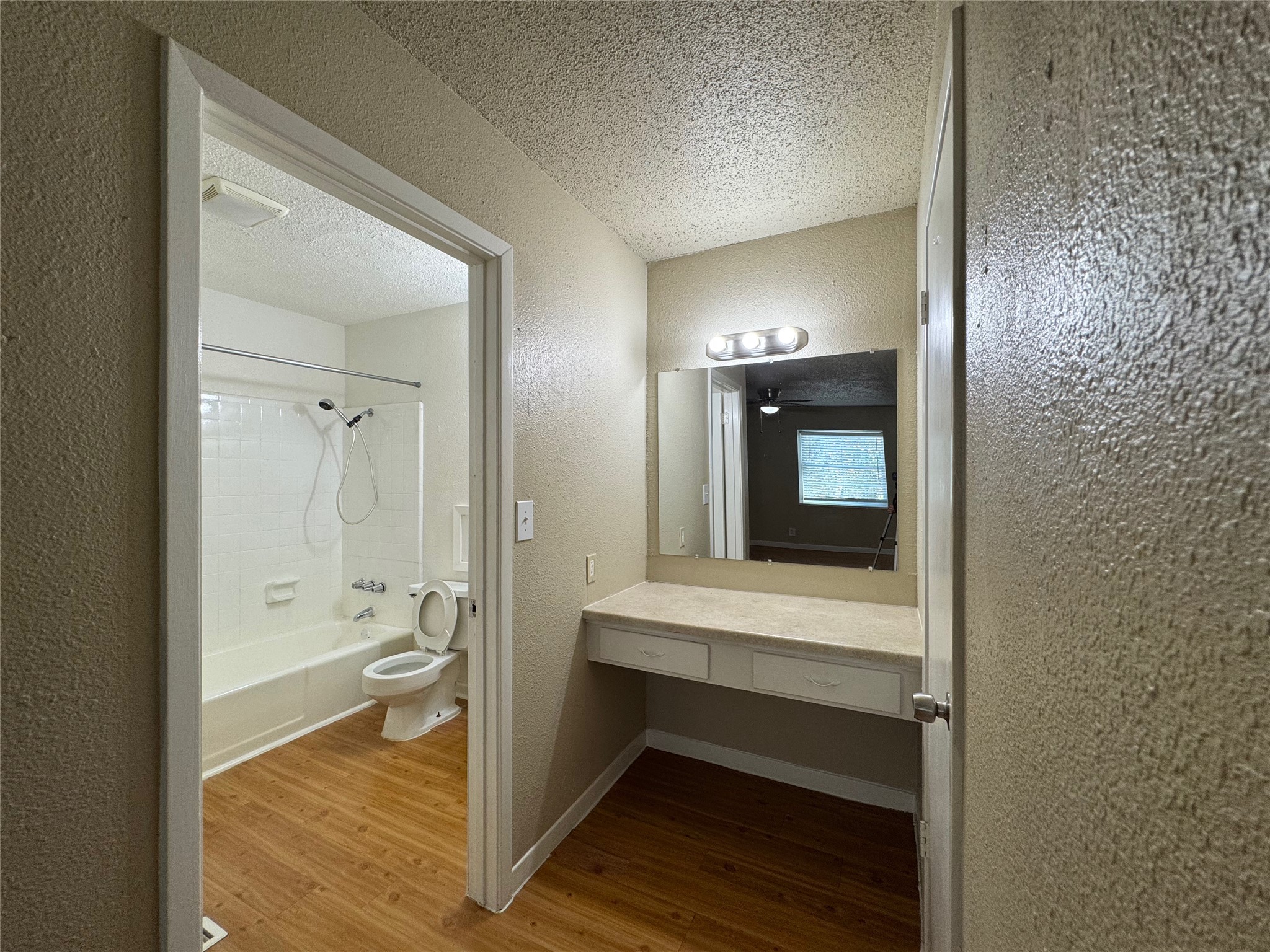 4902 West Wind Trail, Unit 104 Austin, TX 78745 - Photo 12 of 18 a en suite bathroom with a toilet sink and mirror