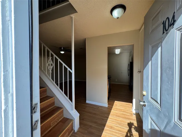 a view of entryway and hall with wooden floor