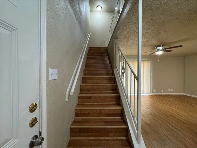 a view of staircase with wooden floor and white walls