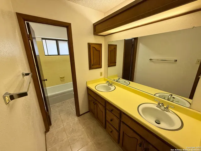 a bathroom with a granite countertop sink and a mirror