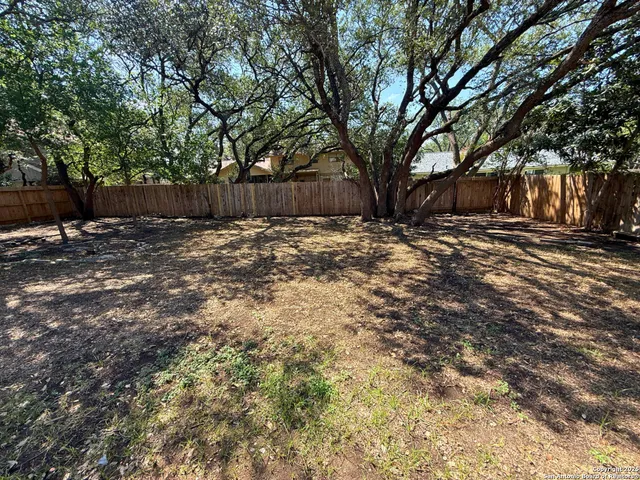 a backyard of a house with large trees