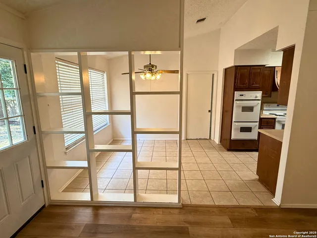 a kitchen with stainless steel appliances wooden floor and a refrigerator