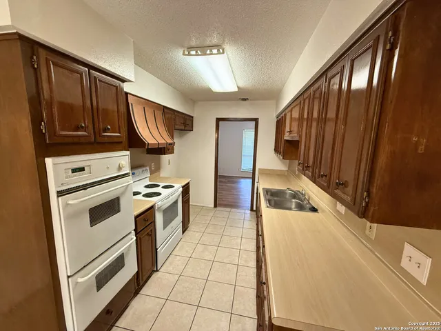 a kitchen with a stove a sink and a refrigerator