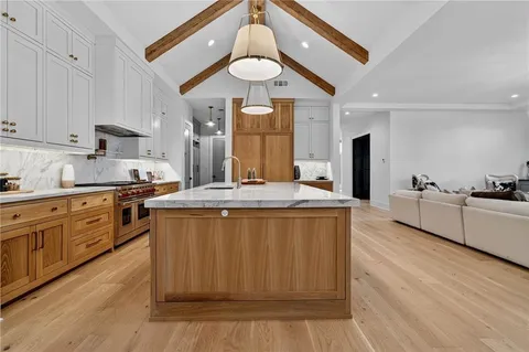 a kitchen with stainless steel appliances granite countertop a sink a stove and refrigerator